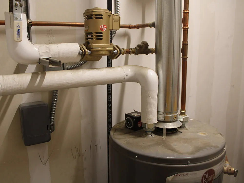 A brass valve and new piping on the water line above a water heater