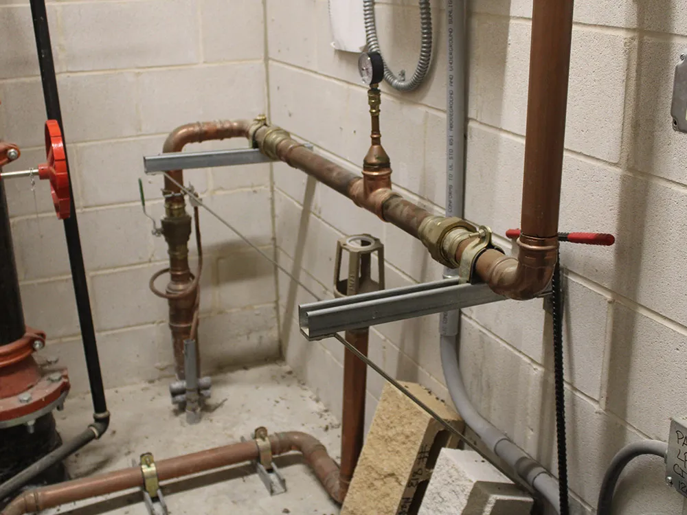 New copper water lines and brass valves installed in a utility room by The Right Guyz