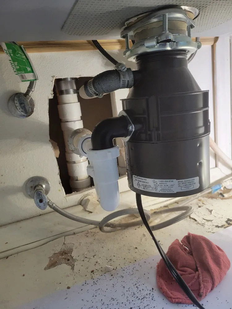 A new garbage disposal installed under a kitchen sink
